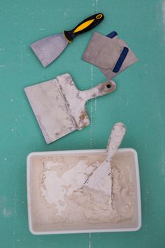 Platering tools for plaster like plaste trowel spatula on green drywall plasterboard