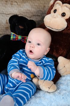 Cute baby boy sitting with his toy bears
