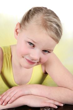 Blond girl wearing a yellow ballet tutu on white background