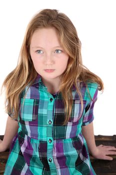 Young teenage girl sitting against white background
