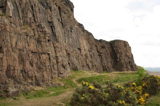 Arthur's Seat is the main peak of the group of hills which form most of Holyrood Park. It is situated in the centre of the city of Edinburgh, about a mile to the east of Edinburgh Castle. The hill rises above the city to a height of 250.5 m (822 ft), provides excellent panoramic views of the city, is relatively easy to climb, and is popular for hillwalking.