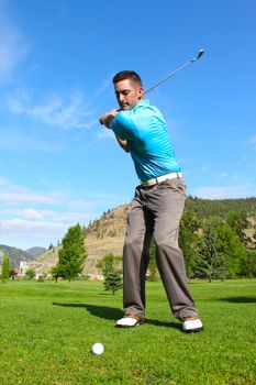 Young golfer hitting a shot with an iron