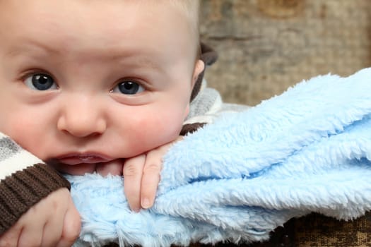 Cute baby boy with a soft blue blanket