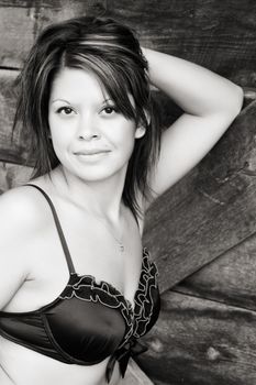 Beautiful brunette female in lingerie againt textured wood background