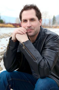 Attractive male outdoors wearing a black leather jacket