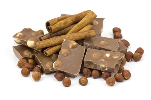 chocolate, cinnamon and nuts on white background