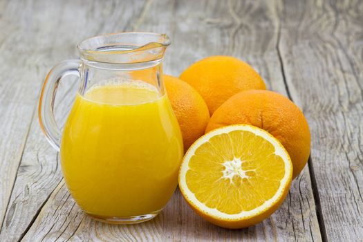 orange juice and fresh fruits on wooden background