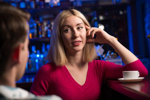 portrait of a nice woman at the bar, talking with a man at the bar date