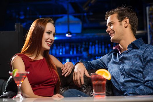 Young couple talking in a nightclub, have fun