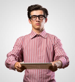 man holds up an electronic tablet, narrowed his eyes and looking at the camera