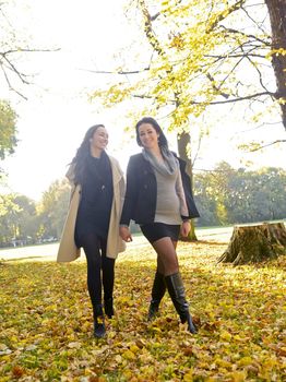 sisters walking in autumn park