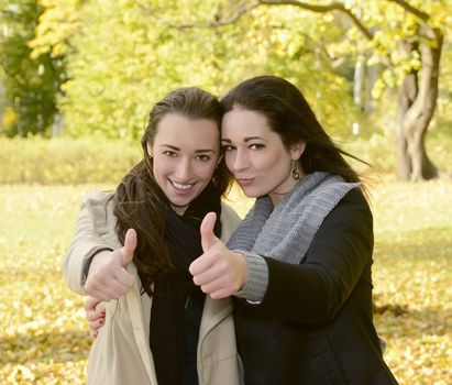 two women showing thumb up