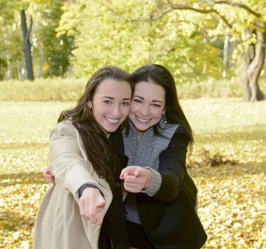 happy sisters pointing with forefinger