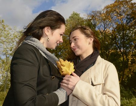 smiling girlfriends in autumn park