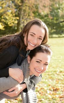 two laughing sisters in autumn park