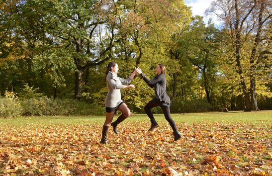 pretty young women dancing in autumn park