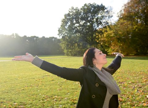 beautiful young woman cheering in autumn park