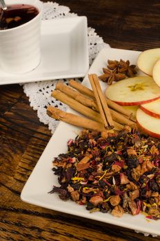 Aromatic fruit tea in a still life with its ingredients