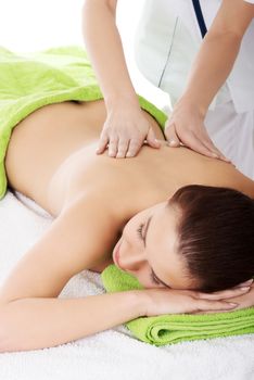 Beautiful woman lying on bed in spa salon having massage. Spa concept.