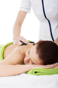 Beautiful woman lying on spa salon having stone massage. Spa concept.