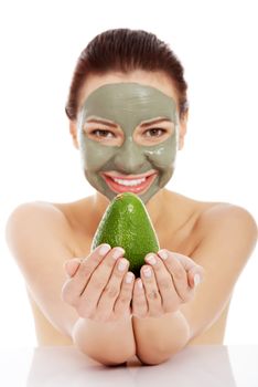 Beautiful woman with facial mask holding avocado. Isolated on white.