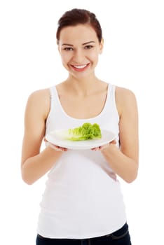 Young beautiful woman holding leaf of lettuce on table. Isolated on white.