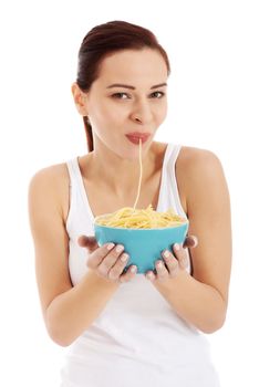 Beautiful woman eating pasta from a bowl. Isolated on white.