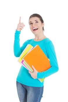 Young beautiful student woman holding workbook and pointing up. Isolated on white.