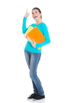 Young beautiful student woman holding workbook and pointing up. Isolated on white.