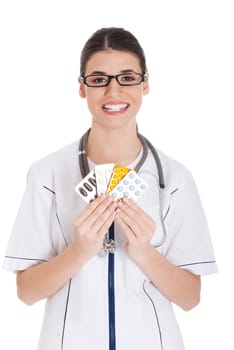 Young female doctor holding pills. Isolated on white.