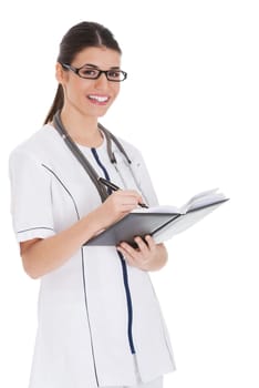 Young female doctor wirting in a book. Isolated on white.