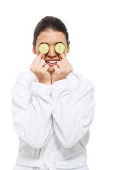 beautiful young woman in bathrobe with cucumber on eyes. isolated on white.