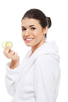 Beautiful woman in bathrobe holding cucumbers. Isolated on white.