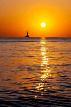Single yacht in the sea at sunset