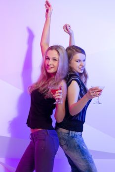 Group stylish women standing in a row toasting with flutes of champagne