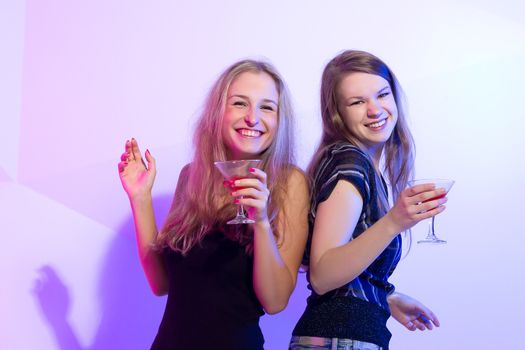 Group stylish women standing in a row toasting with flutes of champagne