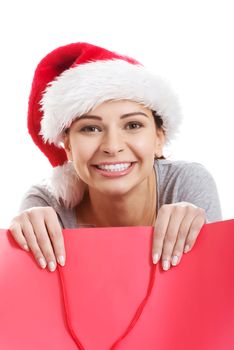 Beautiful woman wearing santa hat, holding shopping bag. Isolated on white.