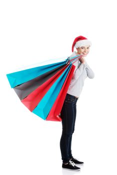 Beautiful woman in santa hat carrying shopping bags. Isolated on white.