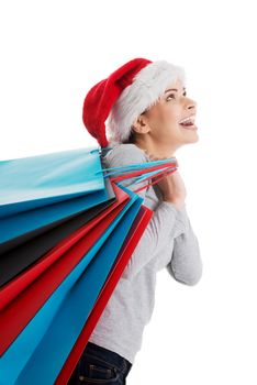 Beautiful woman in santa hat carrying shopping bags. Isolated on white.