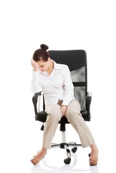 Young beautiful business woman sitting on a chair and looking tired, broken. Isolated on white.