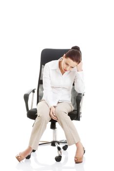 Young beautiful business woman sitting on a chair and looking tired, broken. Isolated on white.