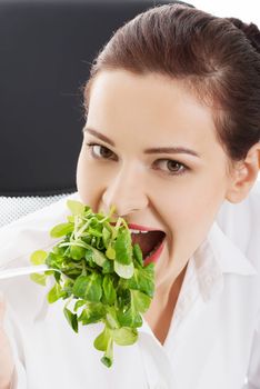 Beautiful business woman sitting and eating lettuce. Close up.