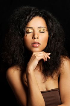 Beautiful mulatto woman with tiger make up. Over black background.