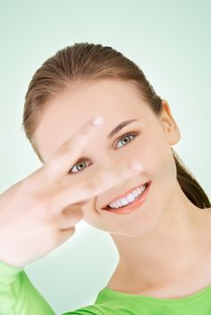 Happy young teenager girl showing victory sign