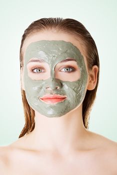 Beautiful woman with green clay facial mask