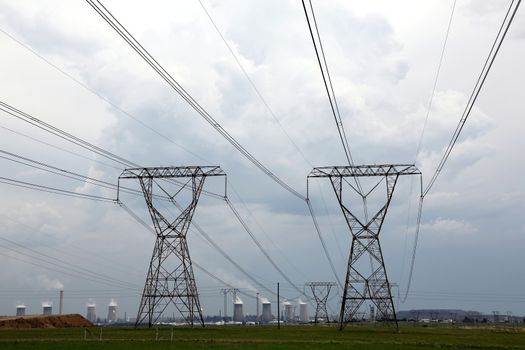 Electricity pylons with energy and fuel production plant in the background