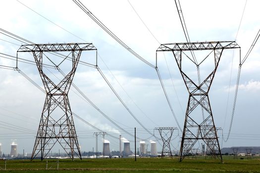 Electricity pylons with energy and fuel production plant in the background