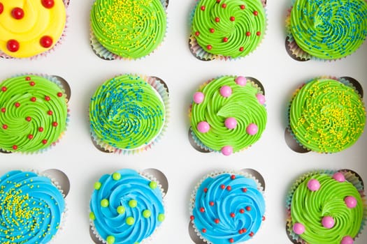 Colorful decorated cupcakes in a white box