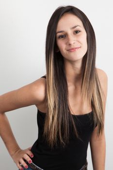 Young caucasian brunette woman posing on a grey background