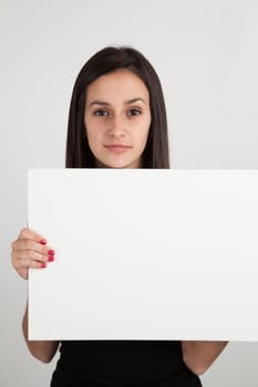 Young brunette caucasian woman holding a blank sign